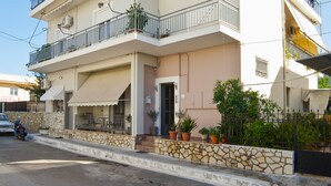 A multi-story residential building with balconies, a stone facade, and potted plants. -  Cute & luxury suite with patio, just few steps away from beach , nearby Delphi (ΙΤΕΑ- ΚΙΡΡΑ)