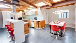 Une cuisine moderne avec des meubles blancs, des éléments décoratifs en bois et un îlot central.