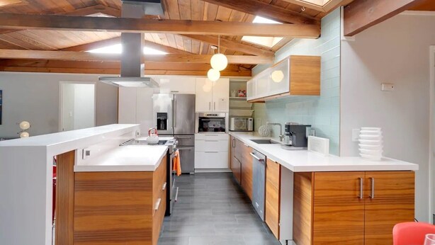 Une cuisine moderne avec des meubles en bois, un îlot central et une lucarne.