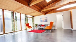 Un vaste espace de vie doté d’un haut plafond, de grandes fenêtres et d’un aménagement intérieur moderne.