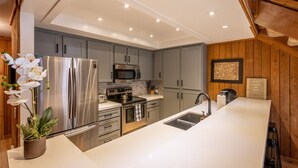 A modern kitchen with stainless steel appliances, grey cabinets, and a white countertop. - Luxe Mountain Cabin Condo, Prime Location Between Cyn Lodge & Village, Sleeps 10 (Mammoth Lakes)