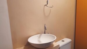 Ein Badezimmer mit einem weißen Waschbecken, einem Wasserhahn und einem Handtuchhalter.