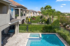 A residential area with a swimming pool, patio furniture, and a well-maintained garden.