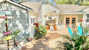 A house with a wooden deck, a small garden, and a birdhouse.