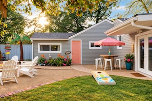 A backyard with a barbecue area, outdoor seating, and a lawn. - The Island – Two Homes, One Paradise! (Lubbock)