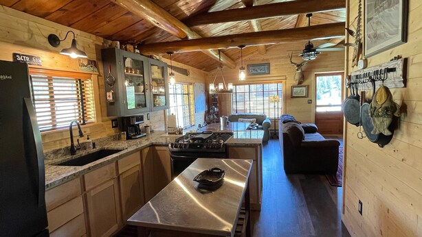 L’intérieur d’un chalet rustique comprenant une cuisine, un coin repas et un salon.