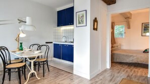 Ein kompakter Wohnbereich mit Essplatz, Küchenzeile und Schlafzimmer.