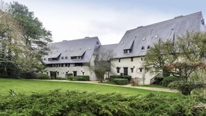 Ein großes, modernes Gebäude mit symmetrischer Gestaltung, mehreren Fenstern und einem zentralen Innenhof.