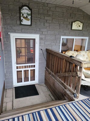 A porch with a wooden fence, a door with a glass panel, and a sign that reads 'GONE FISHING'. - Riverfront Getaway (Bay City)