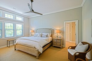 A bedroom with a large bed, two bedside tables with lamps, a ceiling fan, and a window with blinds. - LUXURIOUS RENTAL WITH HEATED, SALT-WATER POOL - 228 NORFOLK, REHOBOTH BEACH (Rehoboth Beach)