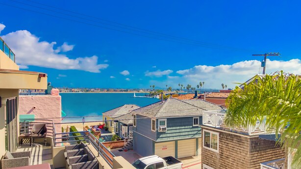 A residential area with a view of the ocean, a parked white truck, and a small building with a garage. - San Diego Beach Home/ Mission Beach,Steps to Ocean&Bay, 2 Car Garage, AC/Heating (San Diego)