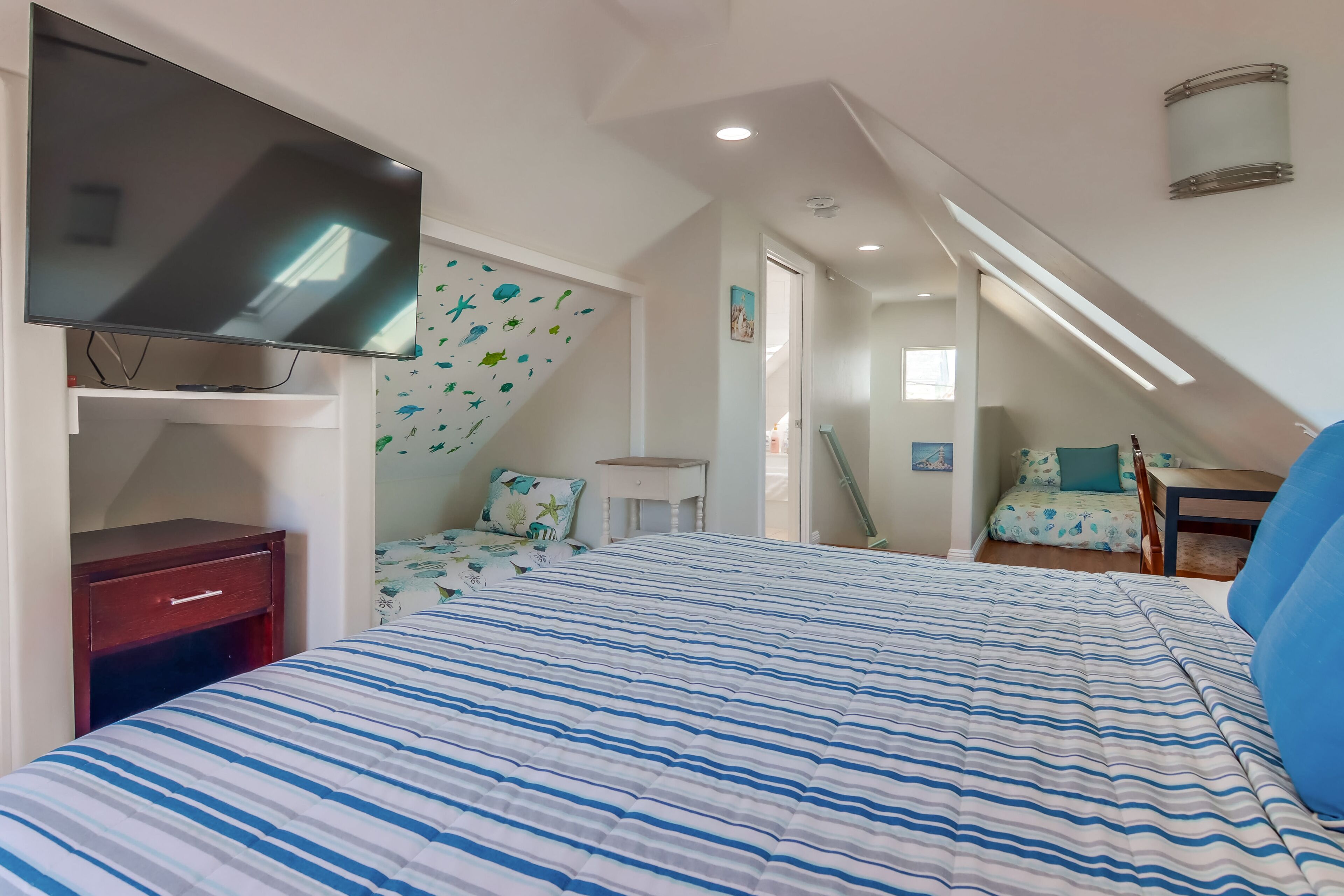 Une chambre à coucher avec un lit, une télévision, un bureau et une chaise.
