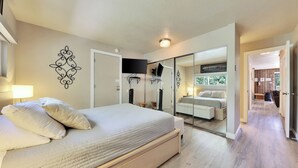 Un dormitorio con cama, mesita de noche y espejo.