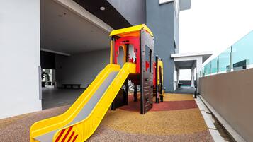 A children's play area with a yellow slide and climbing structures.