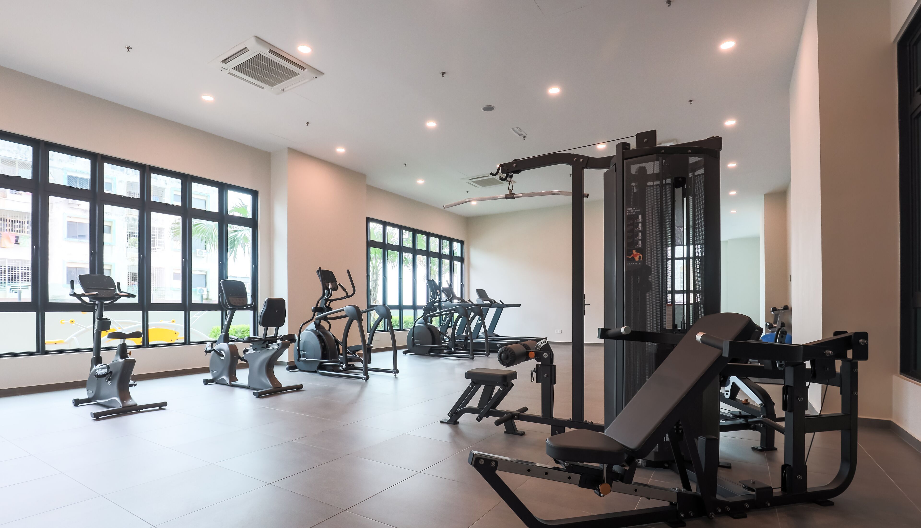 Een moderne sportschool met diverse fitnessapparaten, grote ramen en een overzichtelijke, ruime indeling.