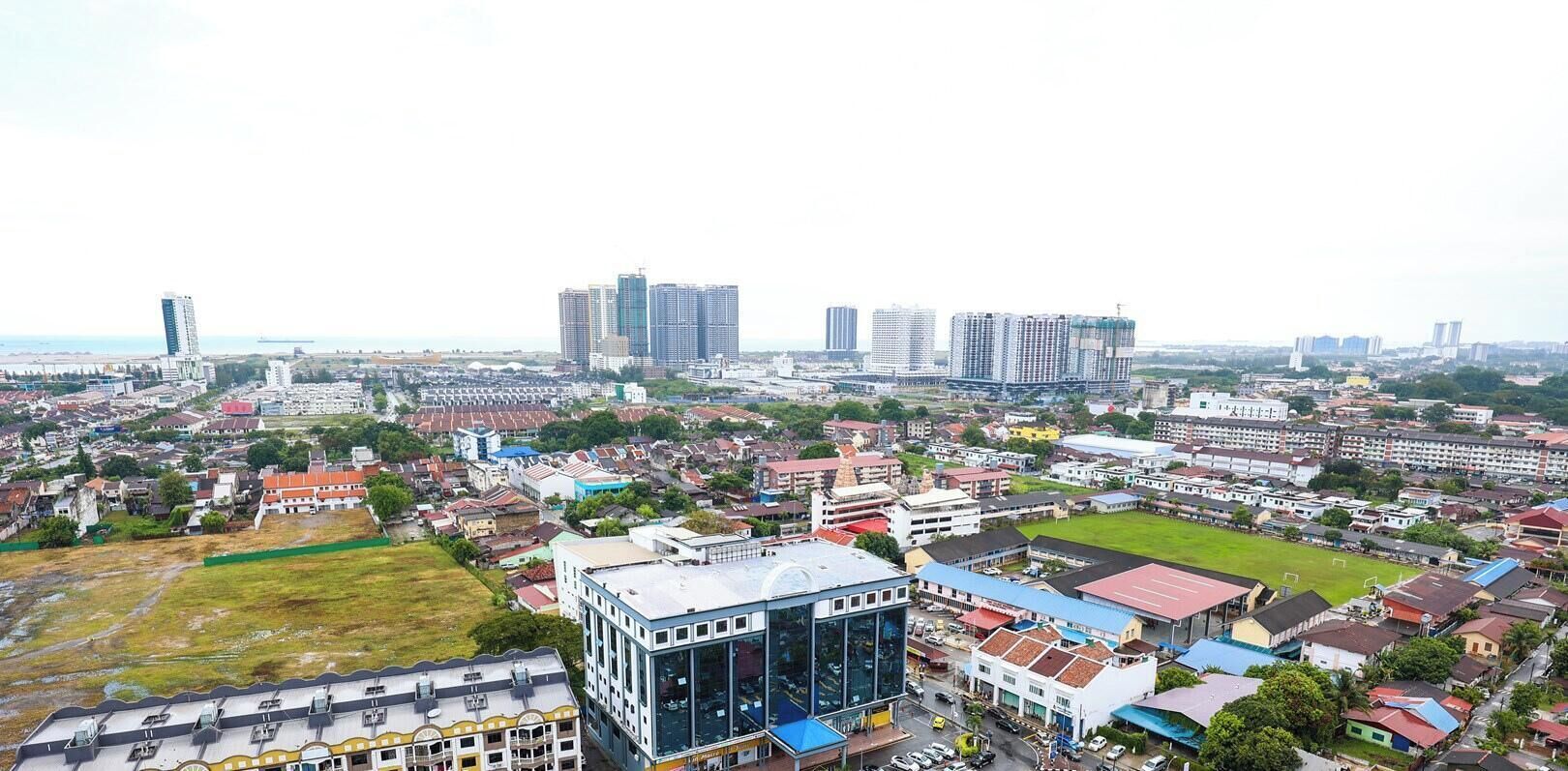 A cityscape with high-rise buildings, a mix of residential and commercial structures, and a central open space.