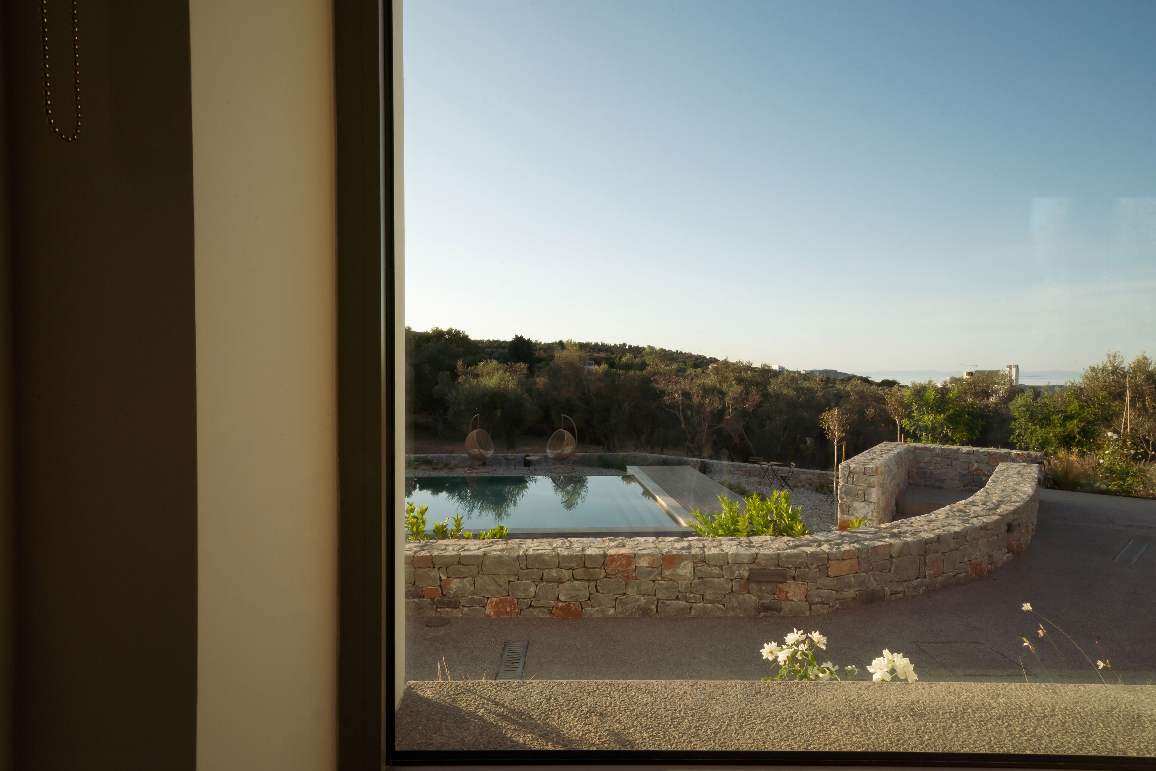 A view of a swimming pool with stone walls and a clear sky.