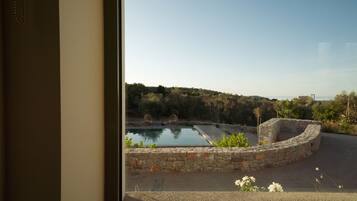 A view of a swimming pool with stone walls and a clear sky.