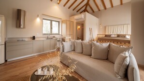 A modern living room with a sofa, a dining area, and a kitchen. - Villa PETRA (ΜΥΤΙΛΗΝΗ)