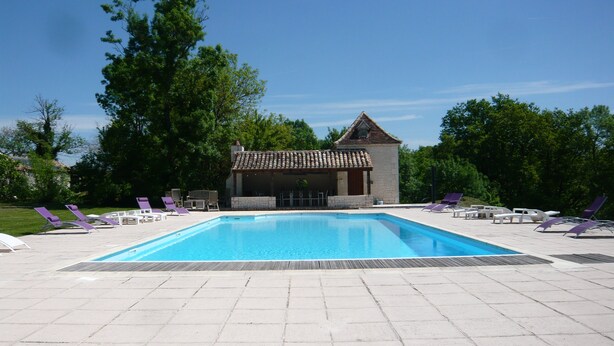 A rectangular swimming pool with a tiled deck, surrounded by lounge chairs and a small building with a tiled roof. - luxury cottage for adult couples, peaceful, unobstructed views, large swimming pool (Boisse, France)
