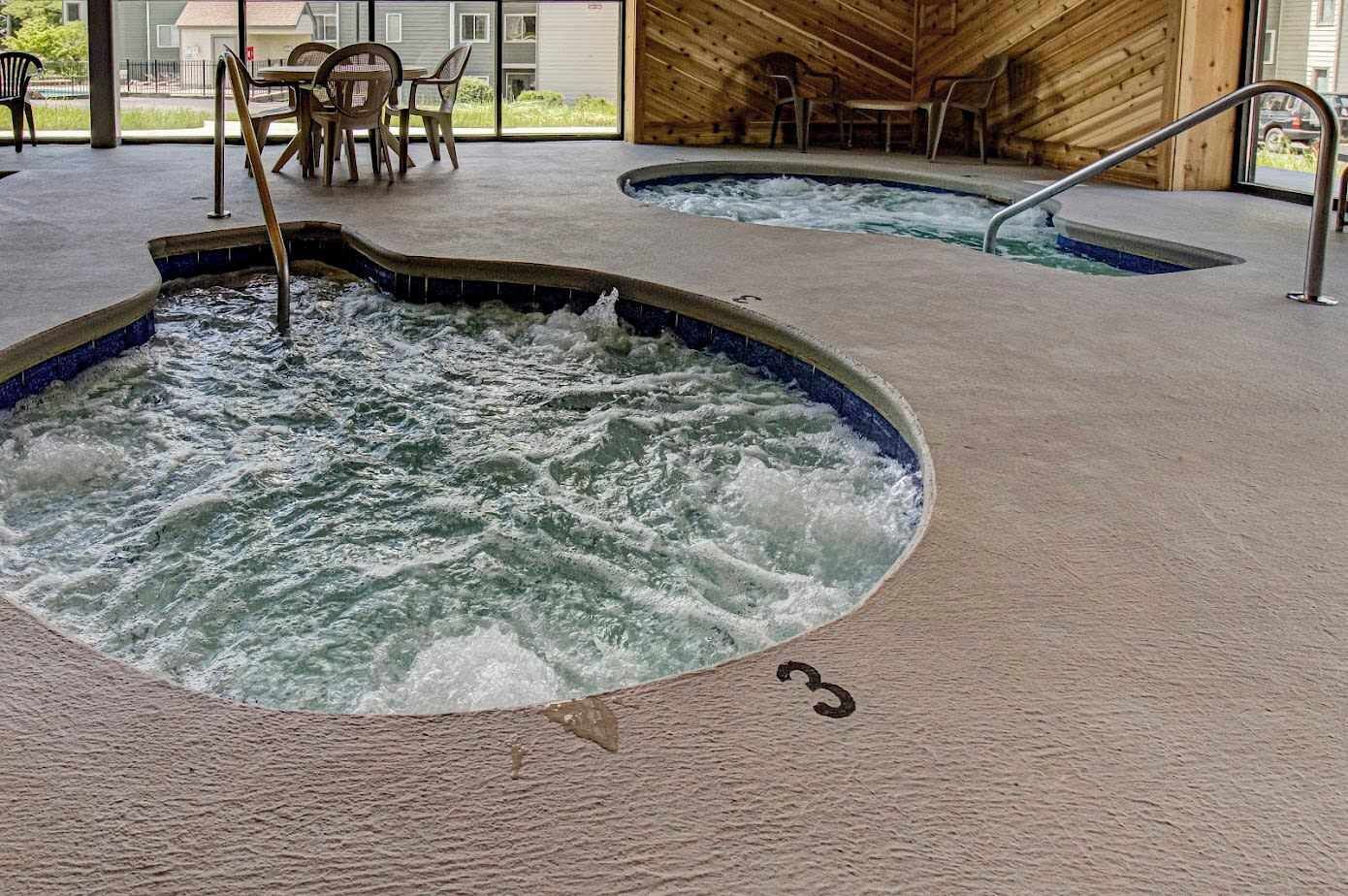 A whirlpool spa area with a wooden interior and a view of the outside.