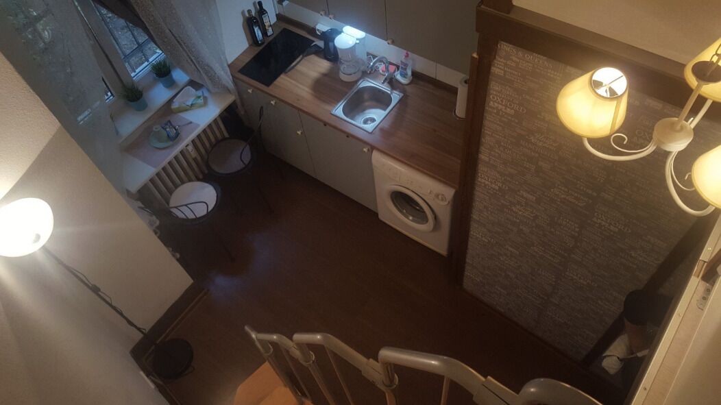 Une cuisine compacte équipée d’un évier, d’une machine à café et d’un lave-linge.