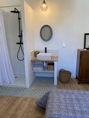 A bathroom with a shower, sink, and mirror. There is a wooden cabinet and a bed with a patterned blanket. - Villa with pool 5 minutes' walk from the beach /A2 (Cavalaire-sur-Mer)