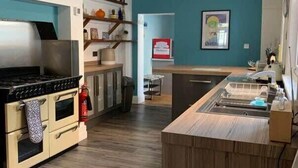 A modern kitchen with a built-in oven, a sink, and wooden countertops. - Howick House - Gorgeous Cosy Filey Cottage style central location - Sleeps 9 (Filey)