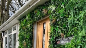 Un bâtiment avec une porte en bois et une enseigne sur laquelle on peut lire : « Maison d’accès à la plage ».