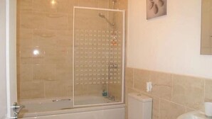 A bathroom with a glass-enclosed shower, a toilet, and a sink. - Jubilee House  - 4 bedroom central house - bright and spacious, 2 parking space (Filey)