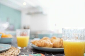 A breakfast setting with croissants and orange juice on a table. - Flora Dora - Luxury cottage, central, beautiful (Filey)