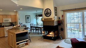 A spacious living room with a fireplace, a dining area, and a kitchen with wooden cabinets and a microwave. - Summer Escape Near Lakes, Trails & Mt Snow (Dover)