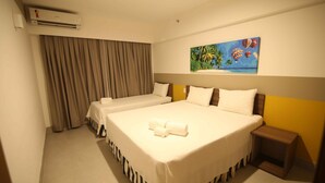 A hotel room with two single beds, a painting of hot air balloons, an air conditioning unit, and a small bedside table. - Enjoy Olimpia Park Resort (SP)