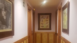 A hallway with wooden paneling, tiled flooring, and framed artwork on the walls. - HTR-40/560 (Sebulcor)