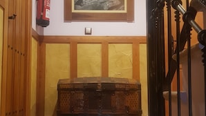 A staircase with a metal railing, a fire extinguisher on the wall, and a framed landscape painting above the steps. - HTR-40/560 (Sebulcor)
