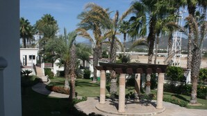 A courtyard with palm trees, a pergola, and a pool. - GATED CONDO 2bd/2bth sleeps 5 Oceanview and Minutes from everything in Cabo! (Cabo San Lucas)