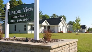 A sign for Harbor View Rentals with a contact number.