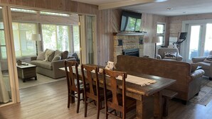 Un amplio salón con una mesa de comedor de madera, asientos acolchados y una chimenea.