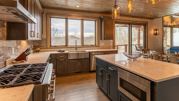 A modern kitchen with a large island, stainless steel appliances, and a view of the outdoors. - Birds Nest Retreat - Eagles Nest Village, hot tub, views, outdoor fireplace! (Banner Elk)
