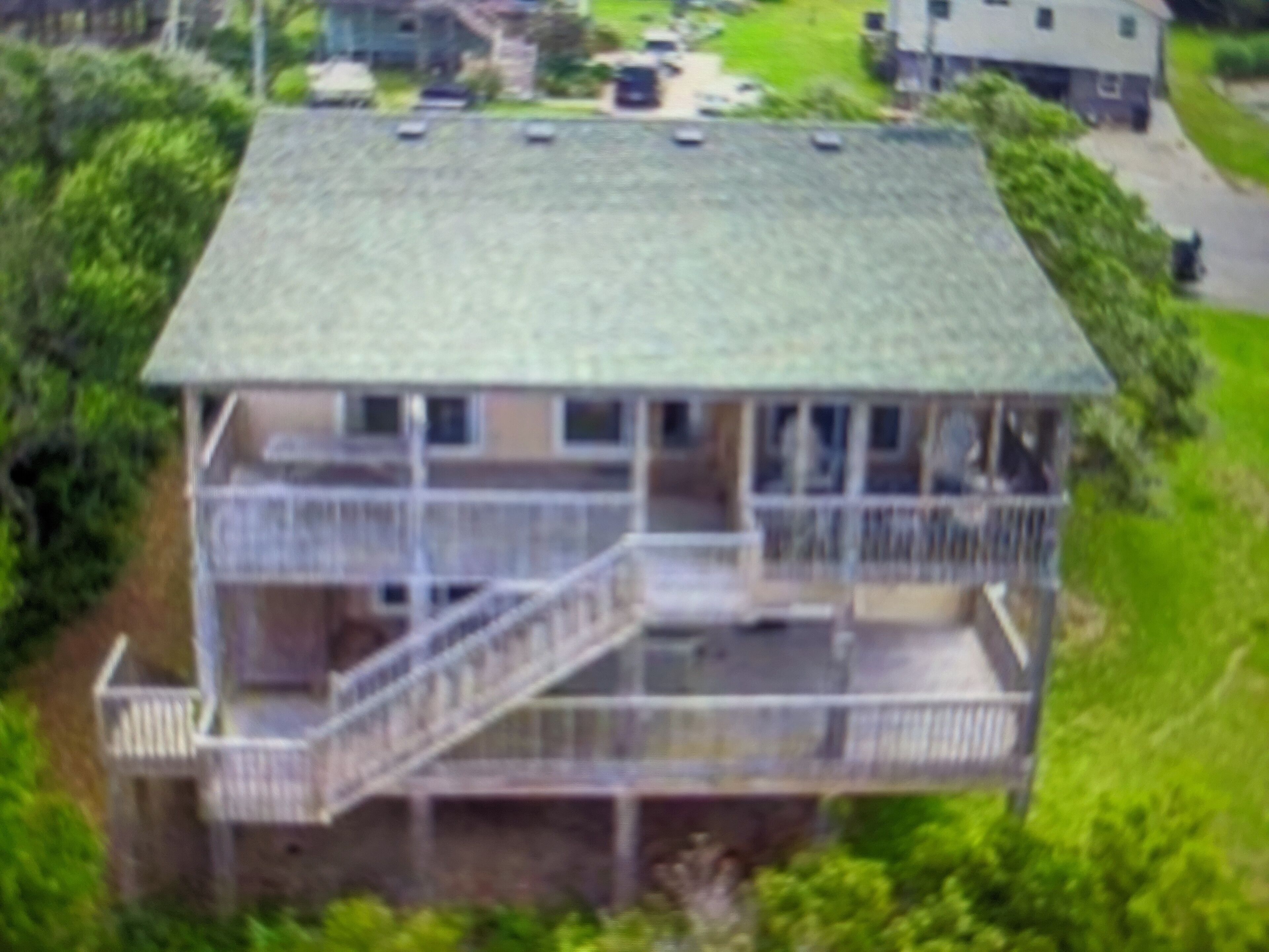 A two-story house with a balcony and a covered porch.