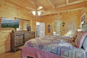 A wooden cabin bedroom with a bed, dresser, and a ceiling fan. - Welcome to Bearfeet Retreat, a pristine cabin in a quiet corner in the heart of Wears Valley. (Sevierville)