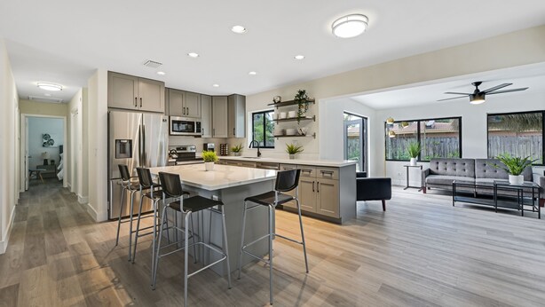 A modern kitchen with a central island, bar stools, and a dining area. - Gorgeous 3B/2B Private Heated Pool mins from the beach  (Pompano Beach)
