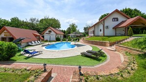 A pool area with lounge chairs, a small pool, and a brick pathway. - Nice home in Rivalno with sauna (Rivalno)