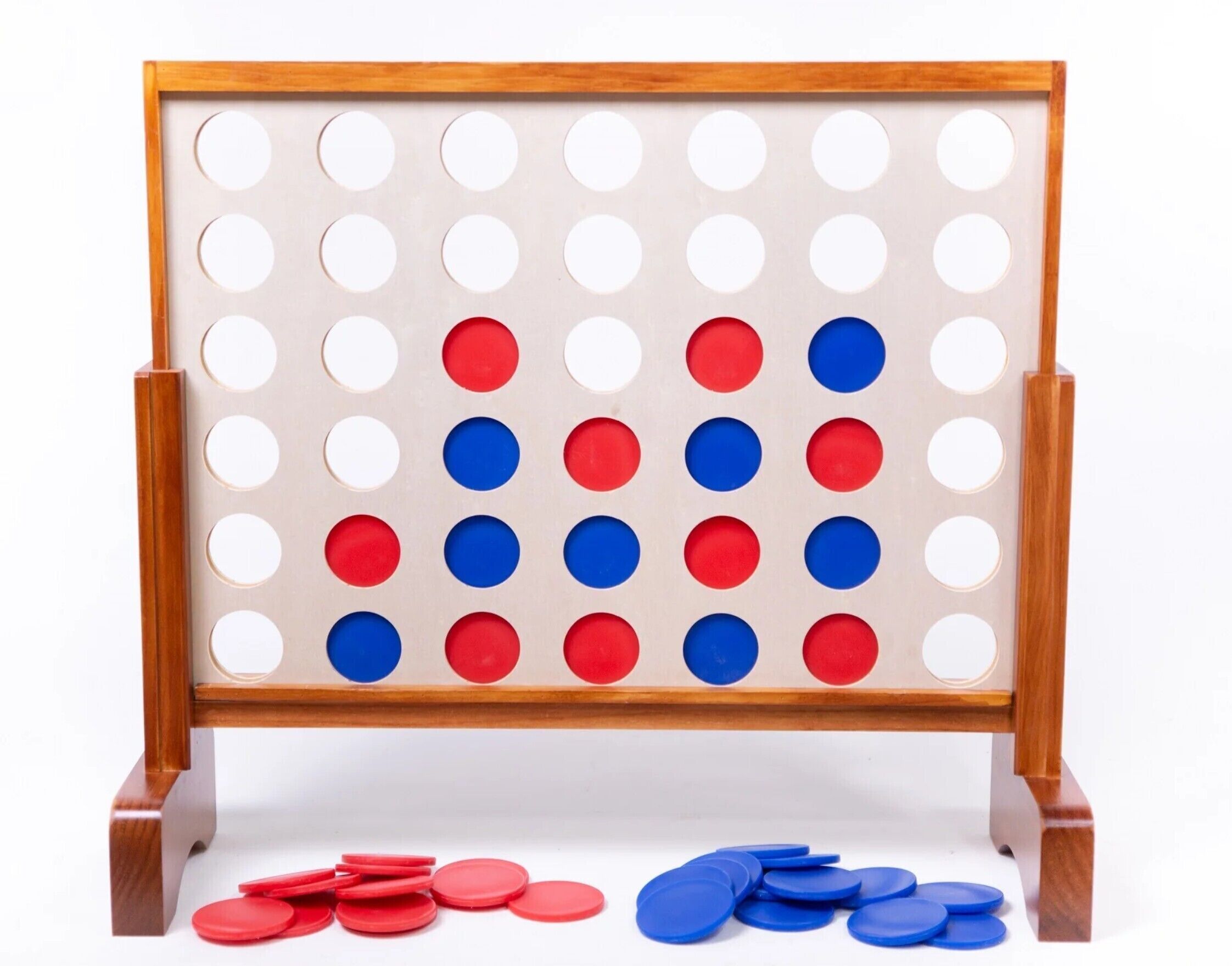 A wooden pegboard with a grid of holes, some filled with red and blue tokens.