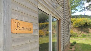 Un mur extérieur en bois, doté d’une porte-fenêtre coulissante et d’une enseigne en bois sur laquelle on peut lire : « Bistro du monde ».