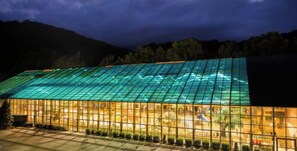 Un grand bâtiment doté d’une façade en verre et d’un toit.