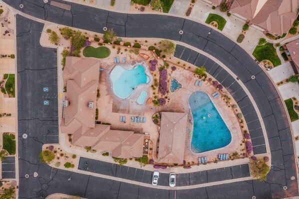 An aerial view of a residential area with two swimming pools, a parking lot, and surrounding greenery. - 4194 Coral Ridge Resort, Dog Friendly, BBQ grill, Private Hot Tub, Community Pool (Washington)