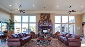A spacious lobby with a stone fireplace, leather sofas, and large windows. - 4194 Coral Ridge Resort, Dog Friendly, BBQ grill, Private Hot Tub, Community Pool (Washington)