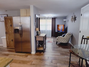 A compact living space with a kitchenette, a dining area, and a seating area with a television. - Private HEATED Pool home in Port Richey / Essentials Provided during your stay  (Port Richey)