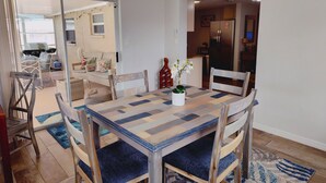 Un coin repas avec une table à carreaux, des chaises rembourrées et une plante en pot.